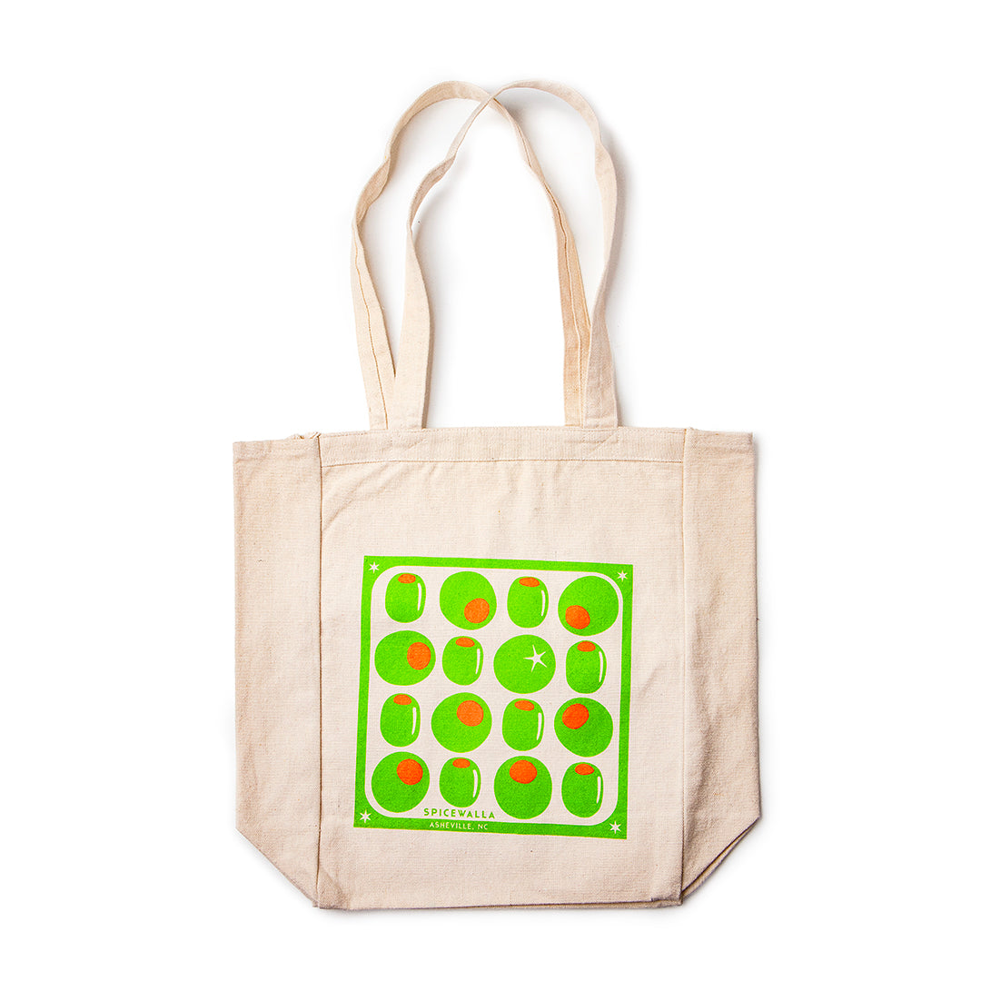 Beige tote bag with green and red pattern on a white background