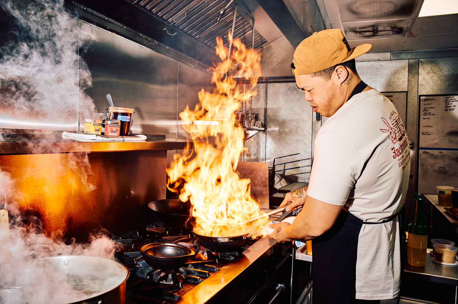 chef shuai wang at the stove cooking with fire!