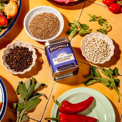Spicewalla seasoning jar surrounded by ingredients on a wooden table
