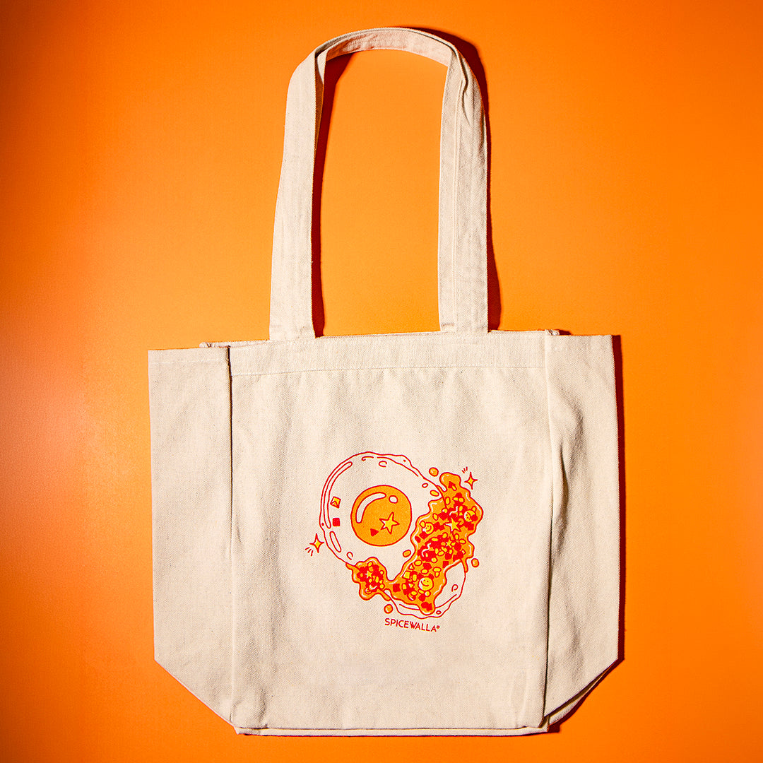 Beige tote bag with orange graphic design on an orange background