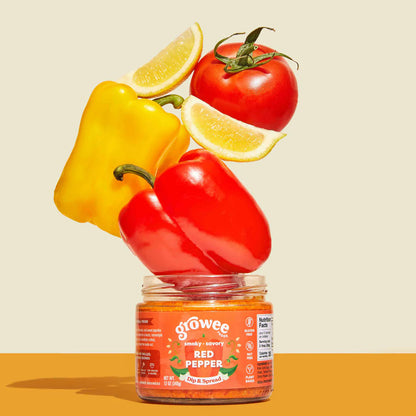 Jar of Growee red pepper on a yellow background with peppers and tomatoes on top