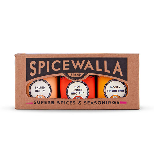 Spicewalla brand spice rubs in a brown cardboard gift box, showing three round spice jars labeled Salted Honey, Hot Honey BBQ Rub, and Honey & Herb Rub.