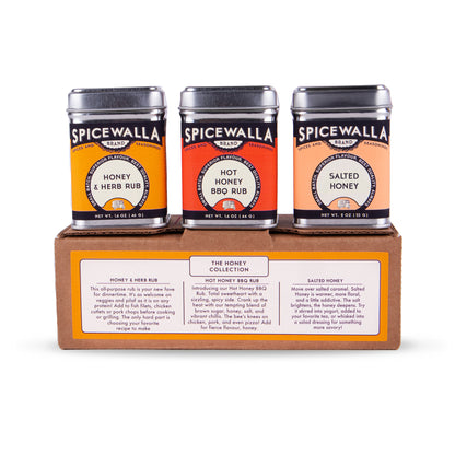 Three Spicewalla Brands rubs and honey jars displayed on a wooden presentation box against a white background.