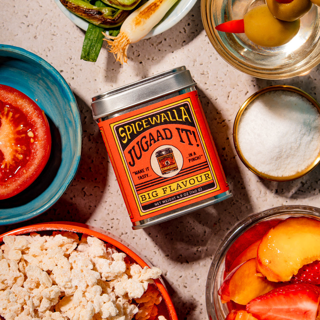 Spicewalla jugaan it! can surrounded by various food items on a textured surface