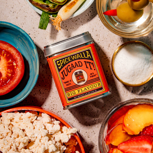 Spicewalla jugaan it! can surrounded by various food items on a textured surface