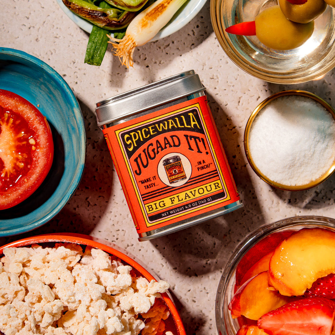 Spicewalla jugaan it! can surrounded by various food items on a textured surface