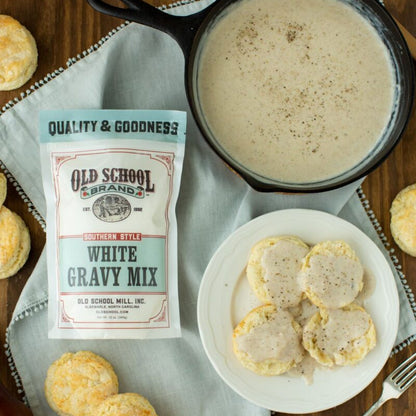 Old School Brand white gravy mix with biscuits and gravy on a wooden table