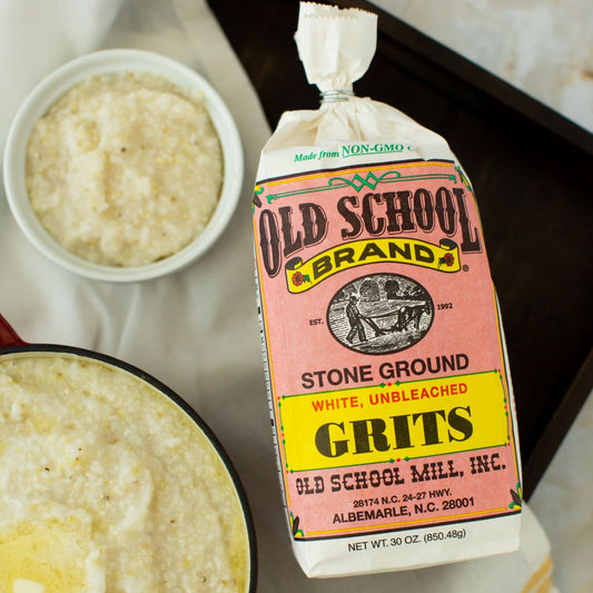 Old School Brand Stone Ground Grits package with a bowl of grits on a table.