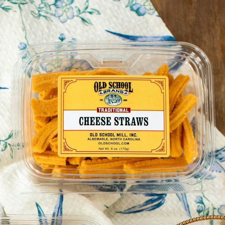 Packaged cheese straws with Old School Brand label on a floral tablecloth