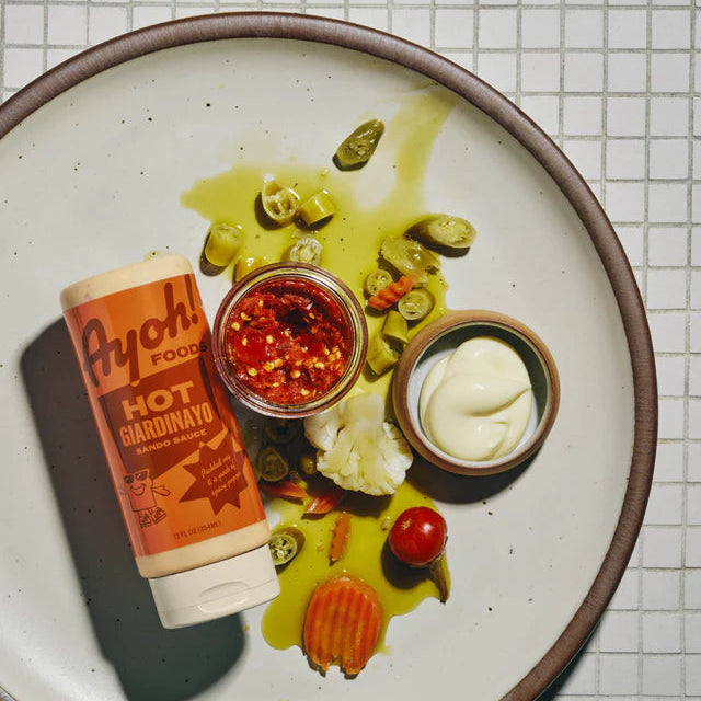 Plate with hot sauce, condiments, and garnishes on a tiled background