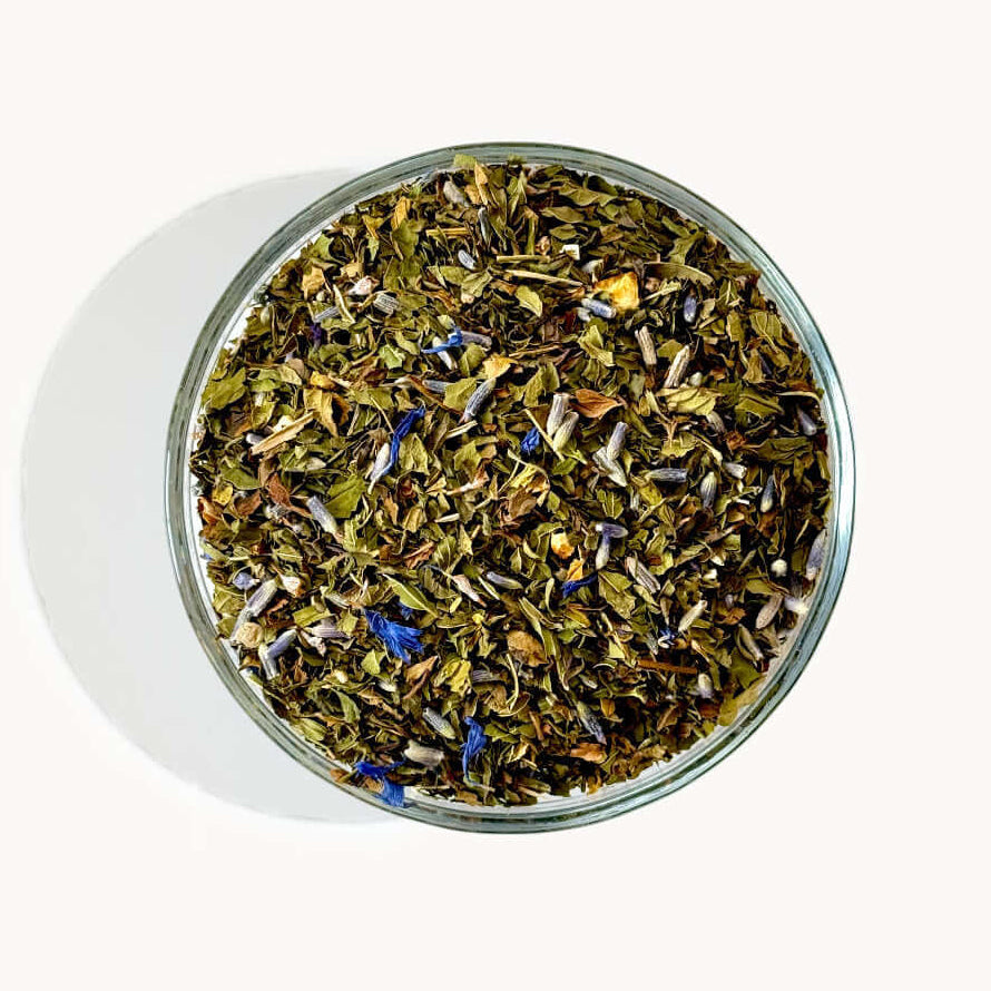 Glass container filled with dried herbs on a white background